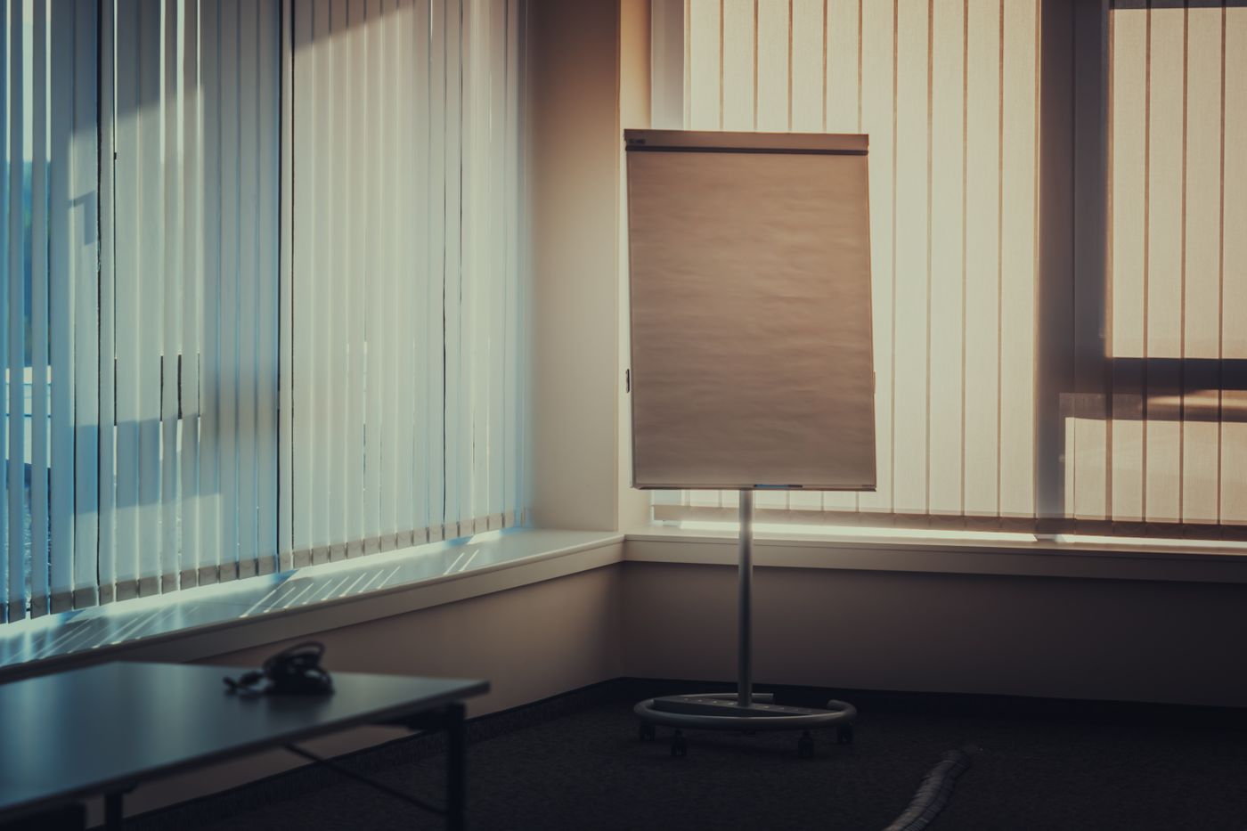 Oficina con cortinas de bandas verticales y escritorio